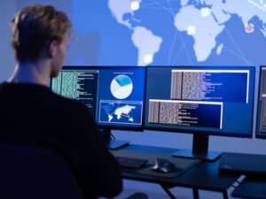 A man sits facing several screens to illustrate what to expect from a managed IT services provider