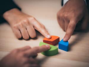 Hands placing pieces together to illustrate the need for a strategic approach to business security