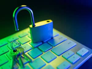 An open lock and keys on a keyboard to illustrate common errors of leaving business network security open to hacking