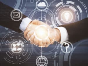business people shaking hands against graphics of technology icons to illustrate partnerships as the future of IT operations and cybersecurity