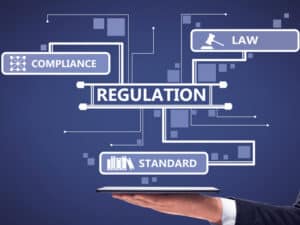 a hand holding an illustration saying compliance, law, regulation, and standard - to illustrate some of the areas managed services support