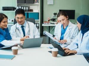 Doctors and nurses discussing patient data, to illustrate the need for HIPAA-compliant IT services
