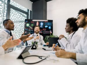 A group of medics talking, to illustrate that inadvertent disclosure of patient information is one of several possible security compliance risks